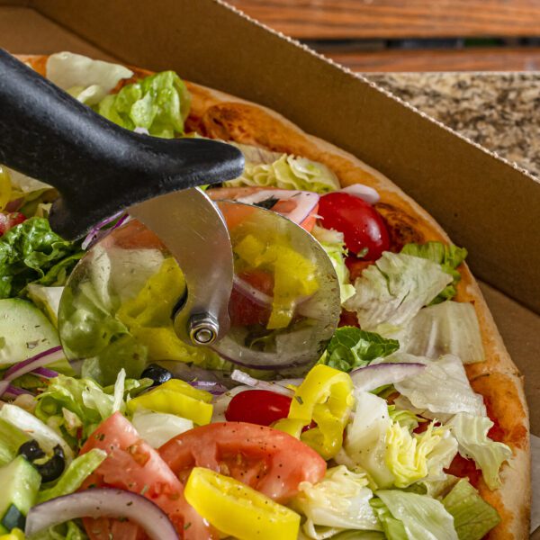 Salad pizza being cut